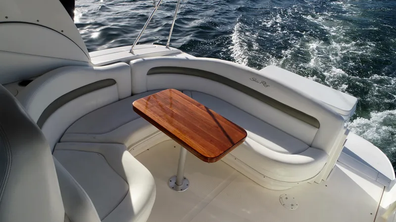Slide: The Image of 2007 Sea Ray 320 Sundancer repowered, cockpit seating with wooden table, on water. - 11