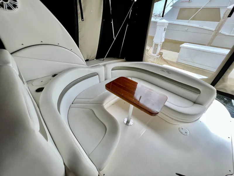 Slide: The Image of 2007 Sea Ray 320 Sundancer repowered, white leather seating area with wooden table. - 2