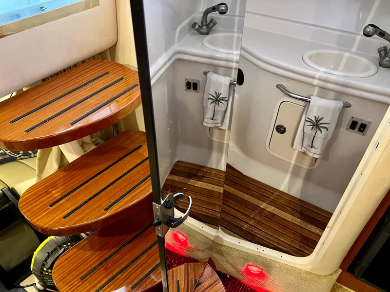 Slide: The Image of 2007 Sea Ray 320 Sundancer repowered, interior bathroom with wooden steps and dual sinks. - 20