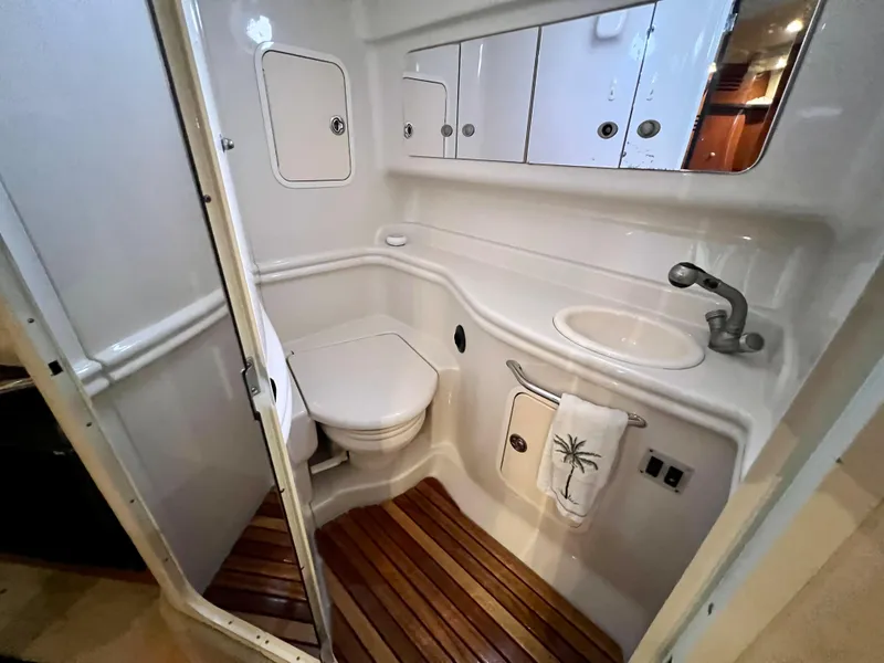 Slide: The Image of 2007 Sea Ray 320 Sundancer repowered bathroom with toilet, sink, and wooden floor. - 24