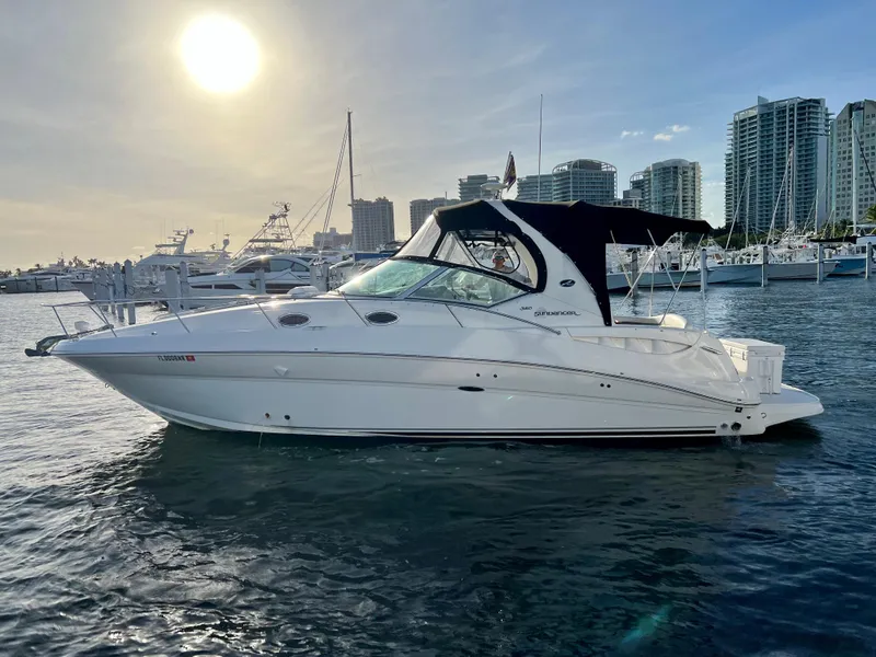 Slide: The Image of 2007 Sea Ray 320 Sundancer repowered yacht docked at marina, city skyline in background. - 8