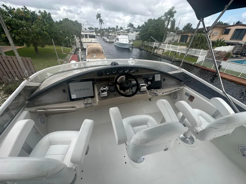Slide: The Image of 2005 Carver 36 Super Sport boat helm with white seating and Garmin navigation. - 14