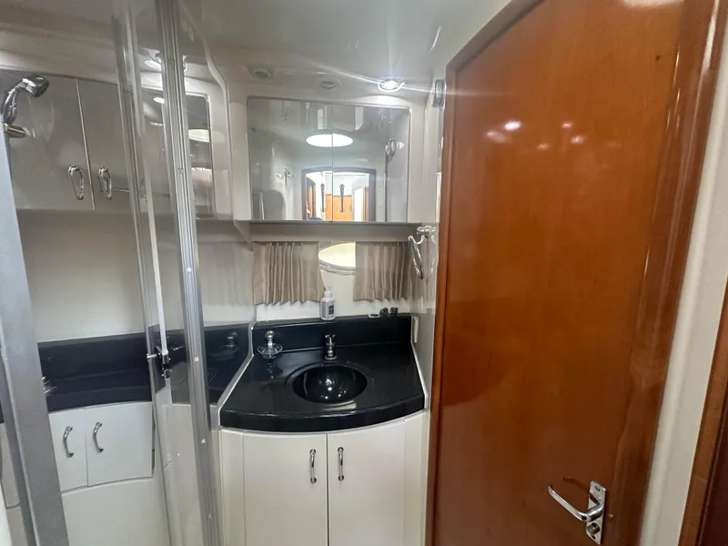 Slide: The Image of 2005 Carver 36 Super Sport bathroom with black countertop and sink. - 19