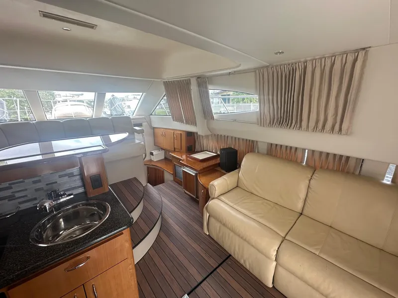 Slide: The Image of Interior of 2005 Carver 36 Super Sport yacht with beige sofa and kitchenette. - 31