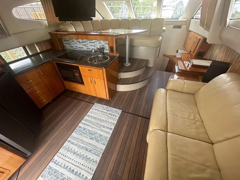 Slide: The Image of Interior of 2005 Carver 36 Super Sport yacht with kitchen, seating, and wood flooring. - 26