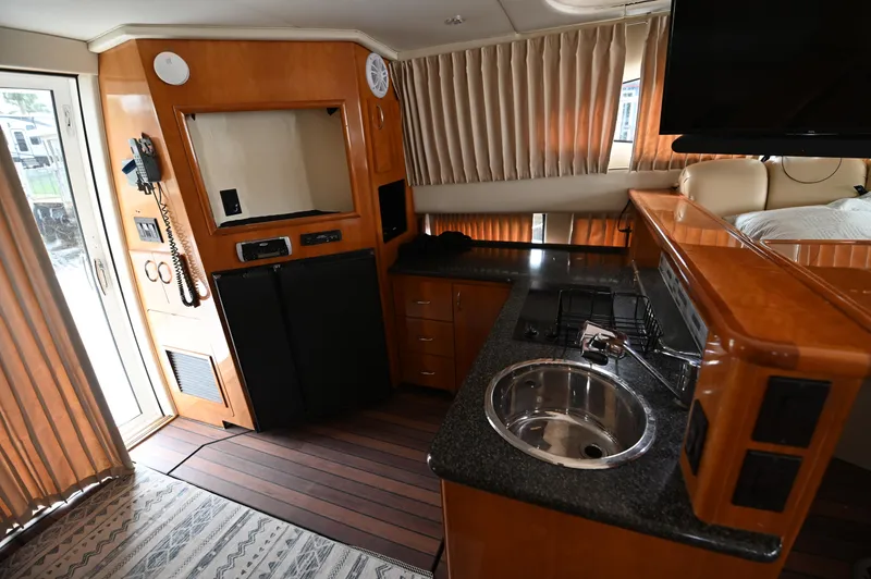 Slide: The Image of Interior of 2005 Carver 36 Super Sport yacht with kitchenette and wood finishes. - 40