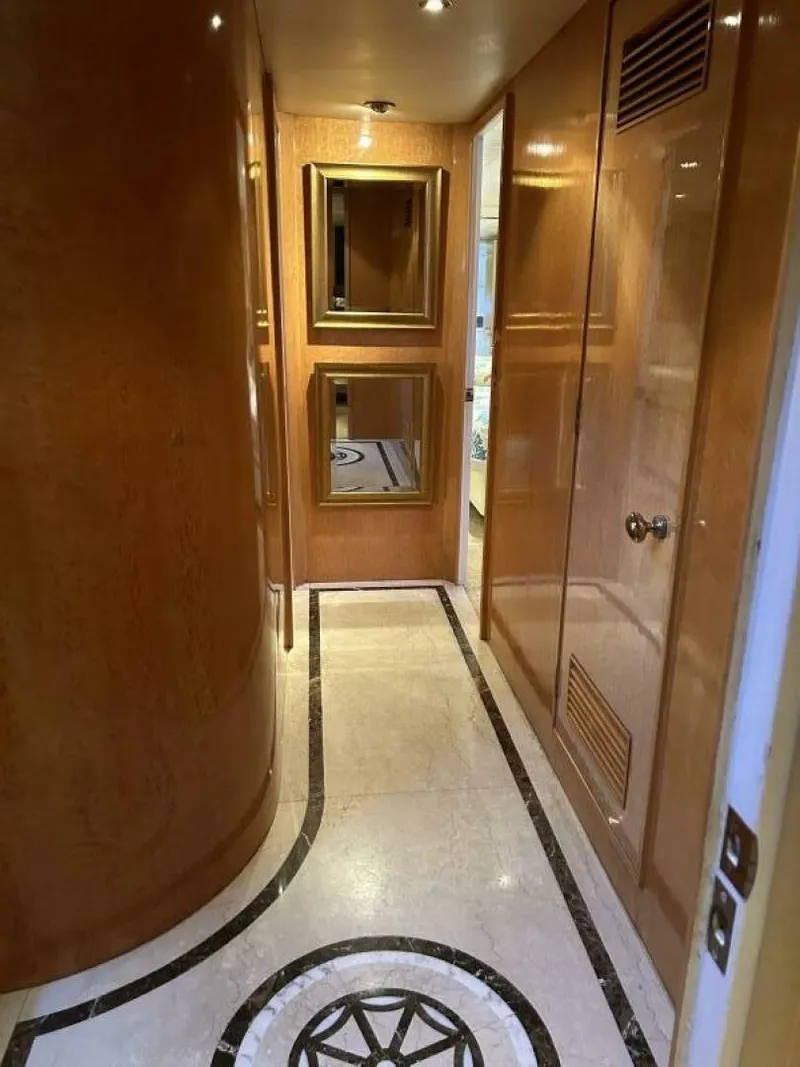 Slide: The Image of Luxurious hallway in 1983 Broward 103 Raised Pilot House yacht with wood paneling and marble floor. - 19