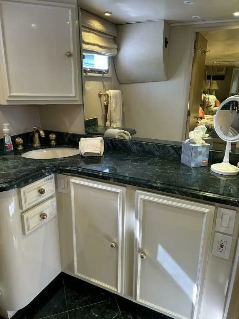 Slide: The Image of Luxurious bathroom in a 1983 Broward 103 Raised Pilot House yacht with marble countertop. - 21
