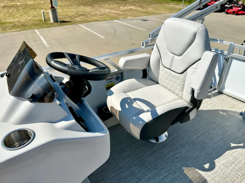 Slide: The Image of 2023 Tahoe Pontoon 19FT STX Cruise captain's chair and helm station in a parking lot. - 5