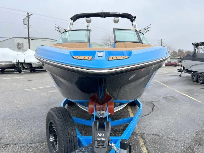 Slide: The Image of 2023 MasterCraft XT23 boat on trailer, front view, blue and black exterior. - 10