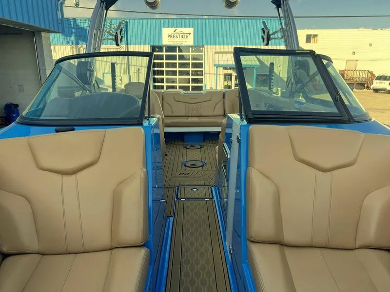 Slide: The Image of 2023 MasterCraft XT23 boat interior with beige seats and blue exterior. - 11