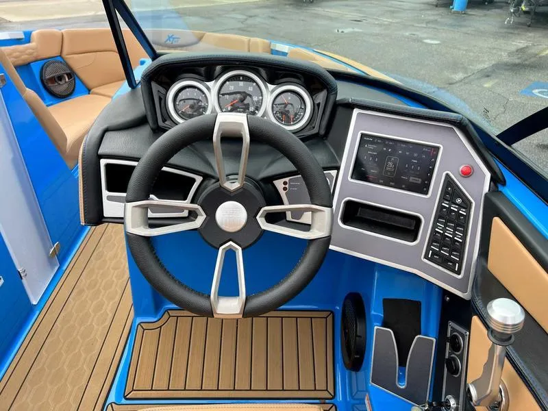 Slide: The Image of 2023 MasterCraft XT23 boat dashboard with steering wheel and control panel. - 2
