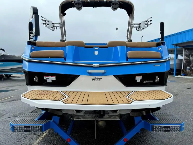 Slide: The Image of 2023 MasterCraft XT23 boat rear view with blue and white exterior. - 7