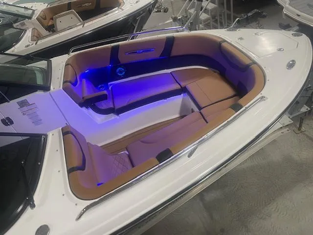 Slide: The Image of 2025 Chaparral 307 SSX boat interior with blue LED lighting and tan seating. - 19