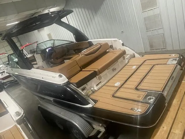 Slide: The Image of 2025 Chaparral 307 SSX boat with luxurious seating and sleek design in a showroom. - 3