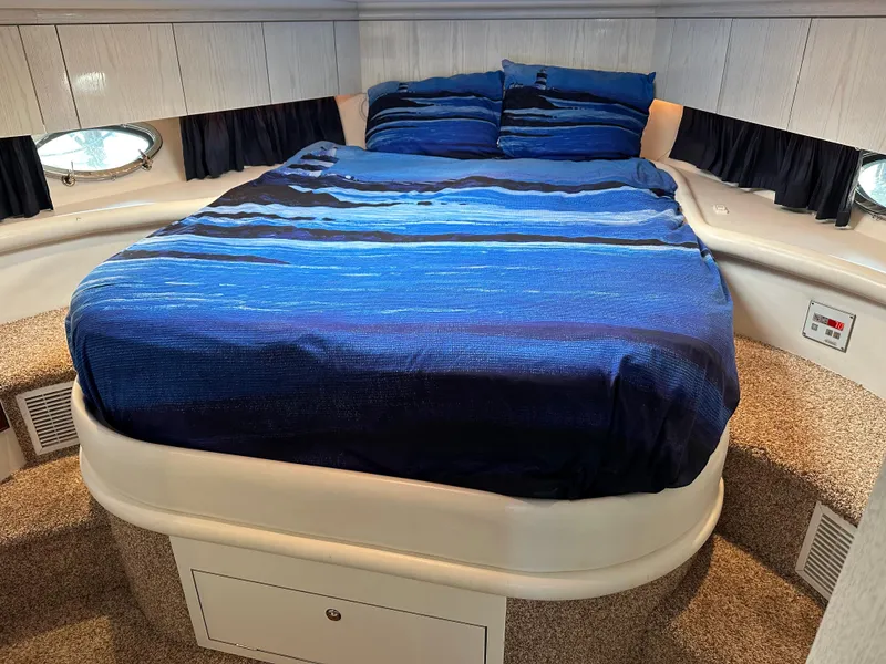 Slide: The Image of Luxurious 1997 Sunseeker Camargue yacht bedroom with blue bedding and elegant design. - 10