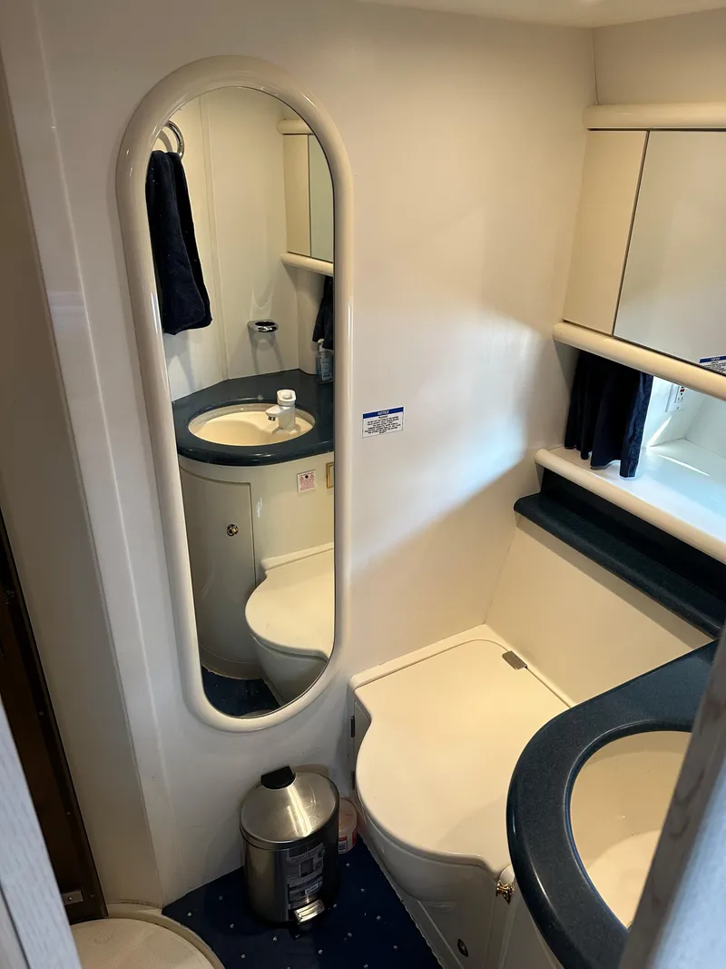 Slide: The Image of 1997 Sunseeker Camargue yacht bathroom with mirror, sink, and storage cabinets. - 12
