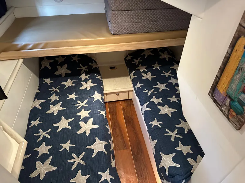 Slide: The Image of 1997 Sunseeker Camargue cabin with starfish-patterned twin beds and wooden flooring. - 6