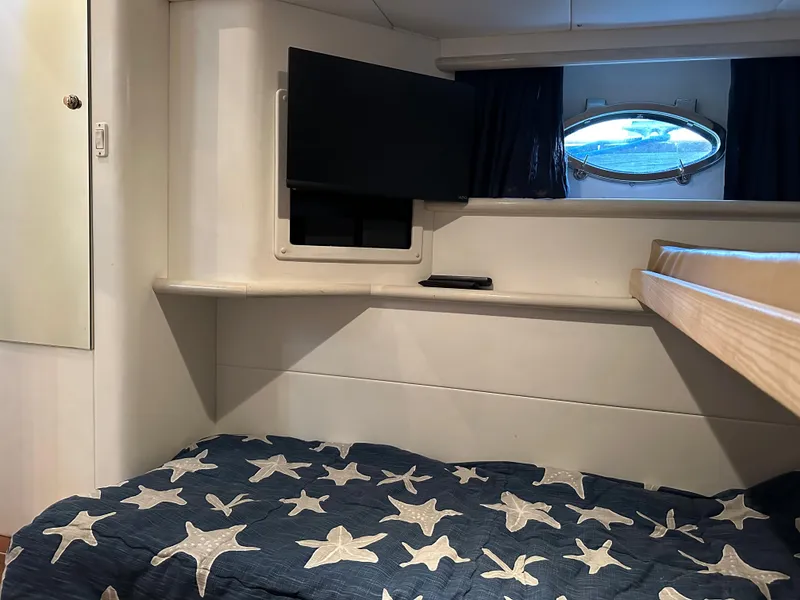 Slide: The Image of 1997 Sunseeker Camargue cabin interior with star-patterned bedding and porthole window. - 7