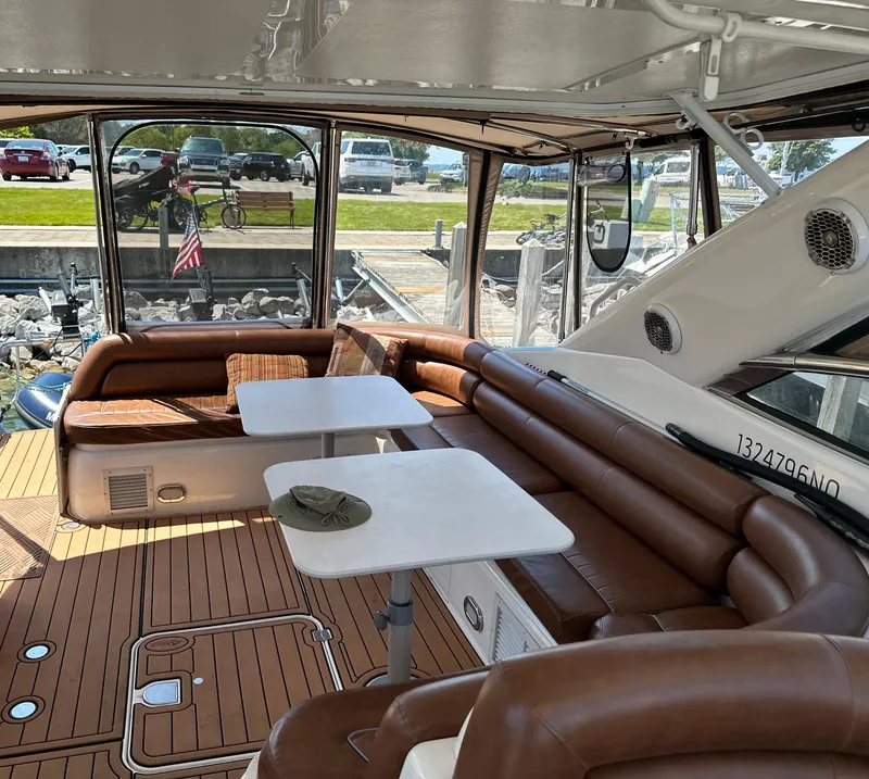 Slide: The Image of 1997 Sunseeker Camargue yacht interior with brown seating and white tables. - 8