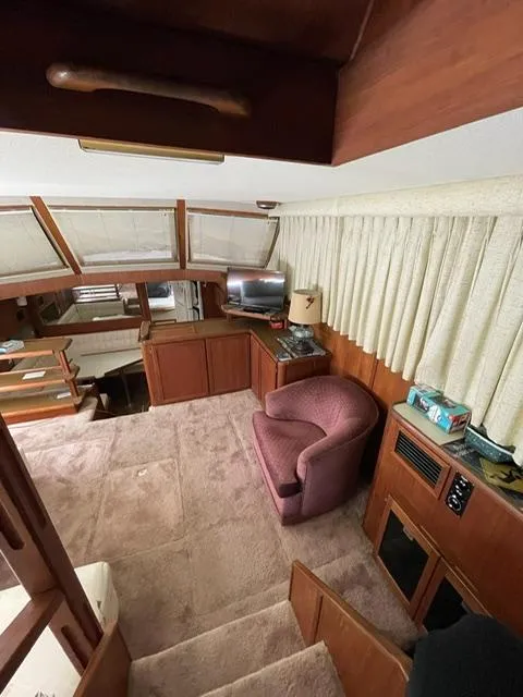 Slide: The Image of Interior of a 1984 Uniflite Double Cabin yacht with cozy seating and wooden cabinetry. - 11