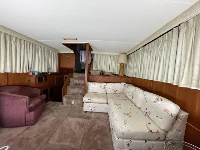 Slide: The Image of 1984 Uniflite Double Cabin interior with floral sofa, armchair, and carpeted floor. - 13