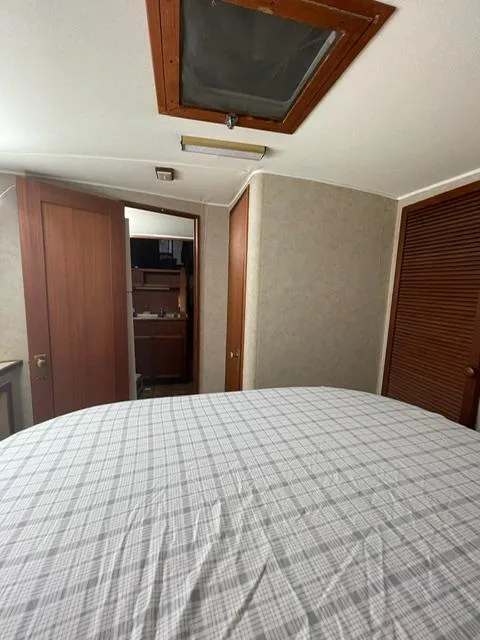 Slide: The Image of 1984 Uniflite Double Cabin interior bedroom with bed, wooden doors, and closet. - 31