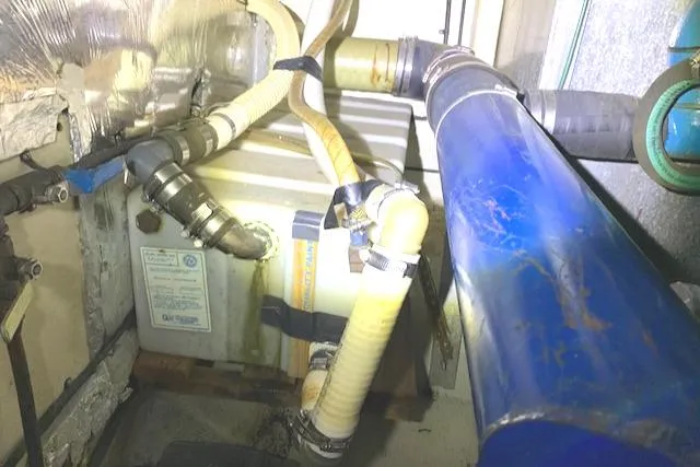 Slide: The Image of 1984 Uniflite Double Cabin engine compartment with hoses and mechanical components. - 37