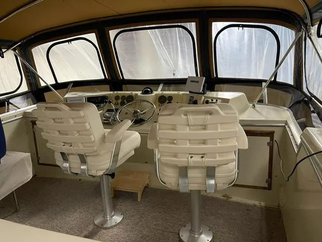 Slide: The Image of 1984 Uniflite Double Cabin boat helm with dual captain chairs and navigation instruments. - 4