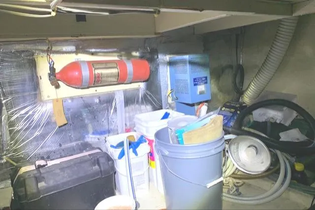Slide: The Image of 1984 Uniflite Double Cabin engine room with fire extinguisher, storage bins, and equipment. - 41