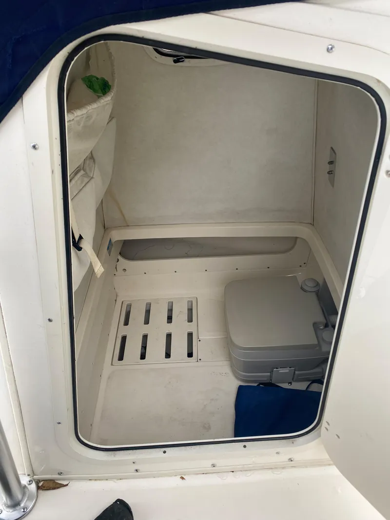 Slide: The Image of 2000 Boston Whaler 23 Outrage boat cabin interior with portable toilet. - 10