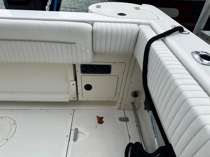 Slide: The Image of 2000 Boston Whaler 23 Outrage boat interior with white cushioned seating and control panel. - 16