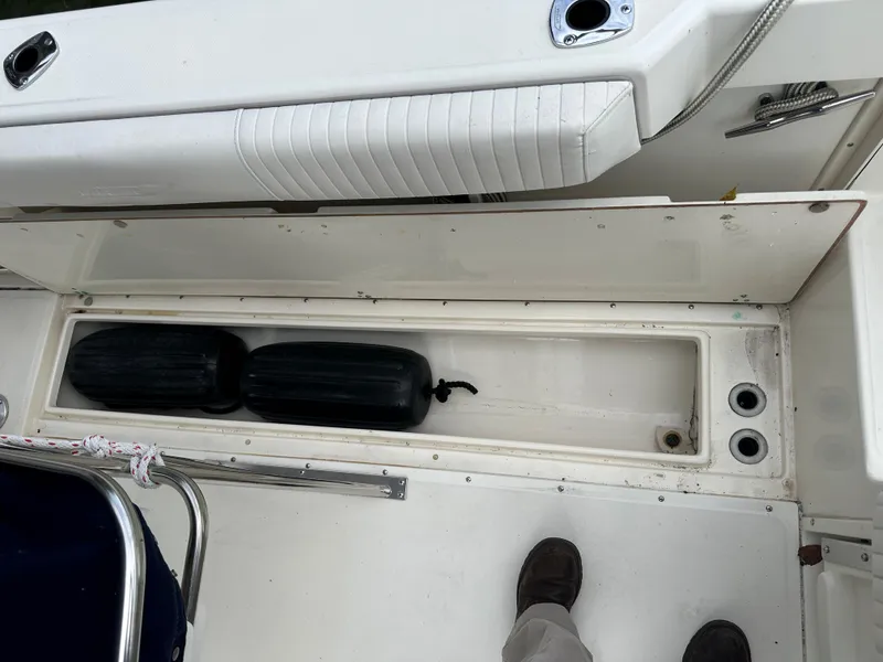 Slide: The Image of Storage compartment on a 2000 Boston Whaler 23 Outrage boat with black fenders. - 18