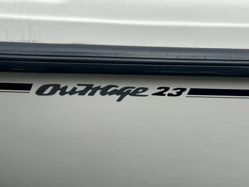 Slide: The Image of 2000 Boston Whaler 23 Outrage model name on boat hull. - 22