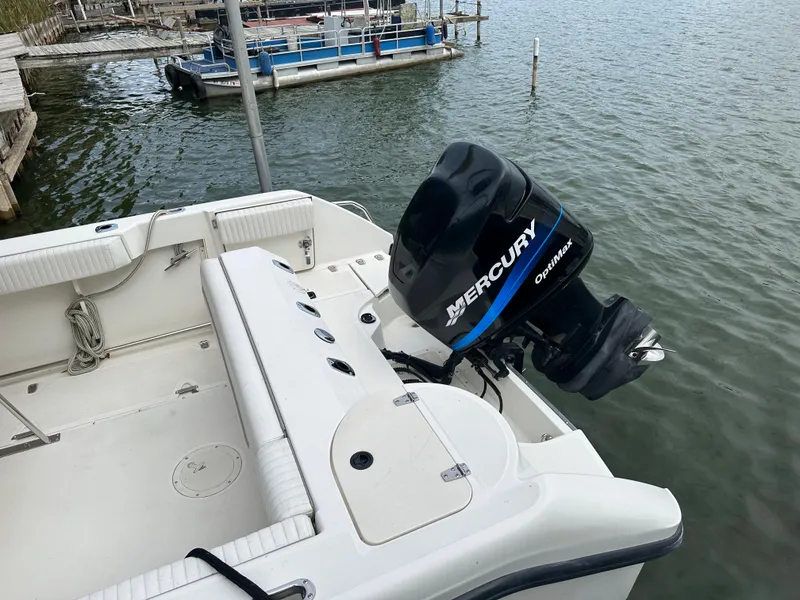 Slide: The Image of Boston Whaler 23 Outrage 2000 boat with Mercury outboard motor docked by the water. - 7