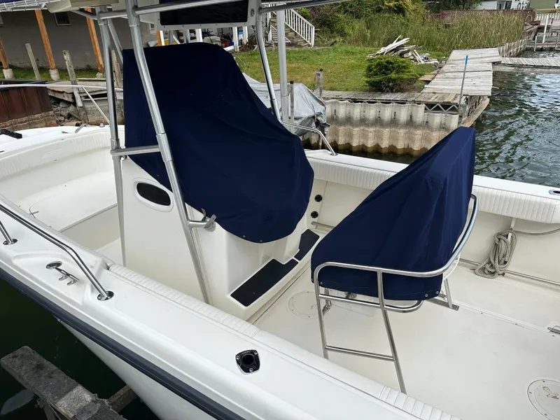 Slide: The Image of 2000 Boston Whaler 23 Outrage boat interior with covered seats at a dock. - 9