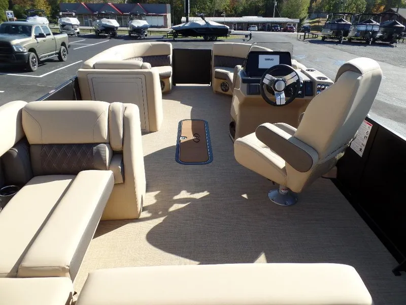 Slide: The Image of 2024 Harris Sunliner 230 pontoon boat interior with beige seating and modern helm. - 13