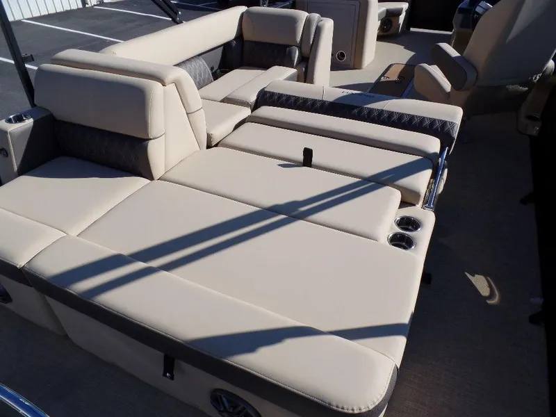 Slide: The Image of 2024 Harris Sunliner 230 boat with beige cushioned seating and cup holders. - 14