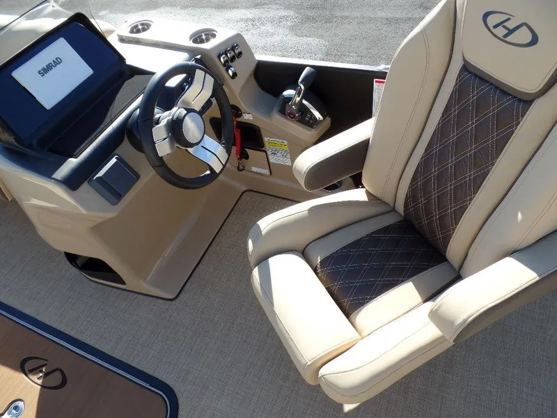 Slide: The Image of 2024 Harris Sunliner 230 boat interior with captain's chair and steering console. - 9