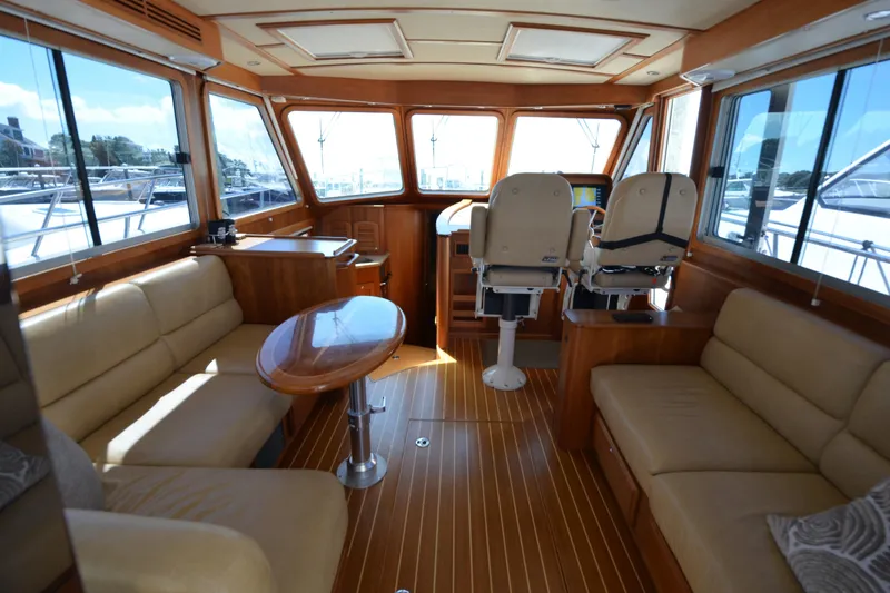 Slide: The Image of 2014 Sabre 42 Salon Express interior with luxurious seating and helm, featuring wood accents. - 14