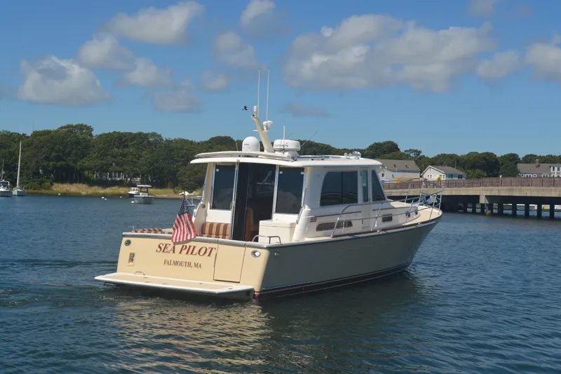 Slide: The Image of 2014 Sabre 42 Salon Express yacht on calm water, Falmouth, MA, with American flag. - 2
