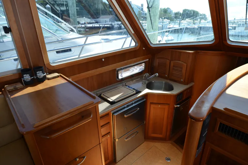 Slide: The Image of 2014 Sabre 42 Salon Express interior with compact kitchen and wooden cabinetry. - 20