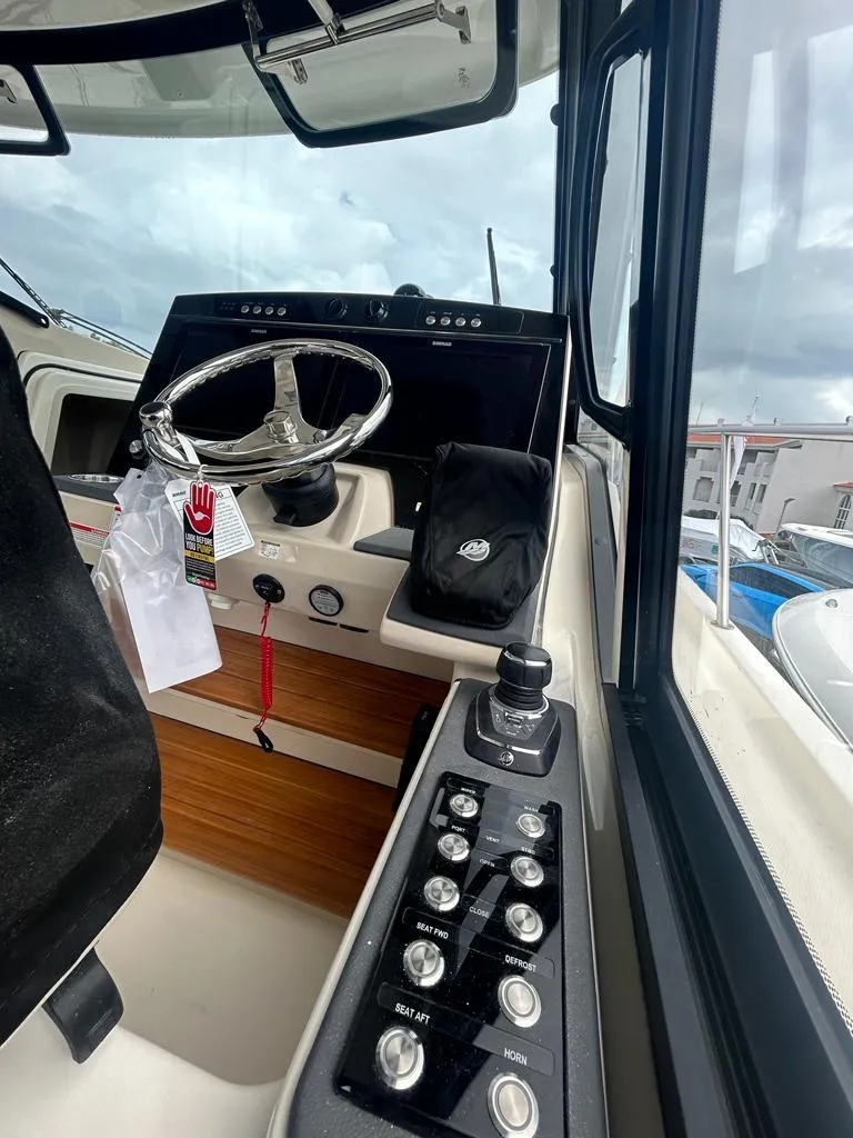 Slide: The Image of 2024 Boston Whaler 405 Conquest helm with modern controls and steering wheel. - 10