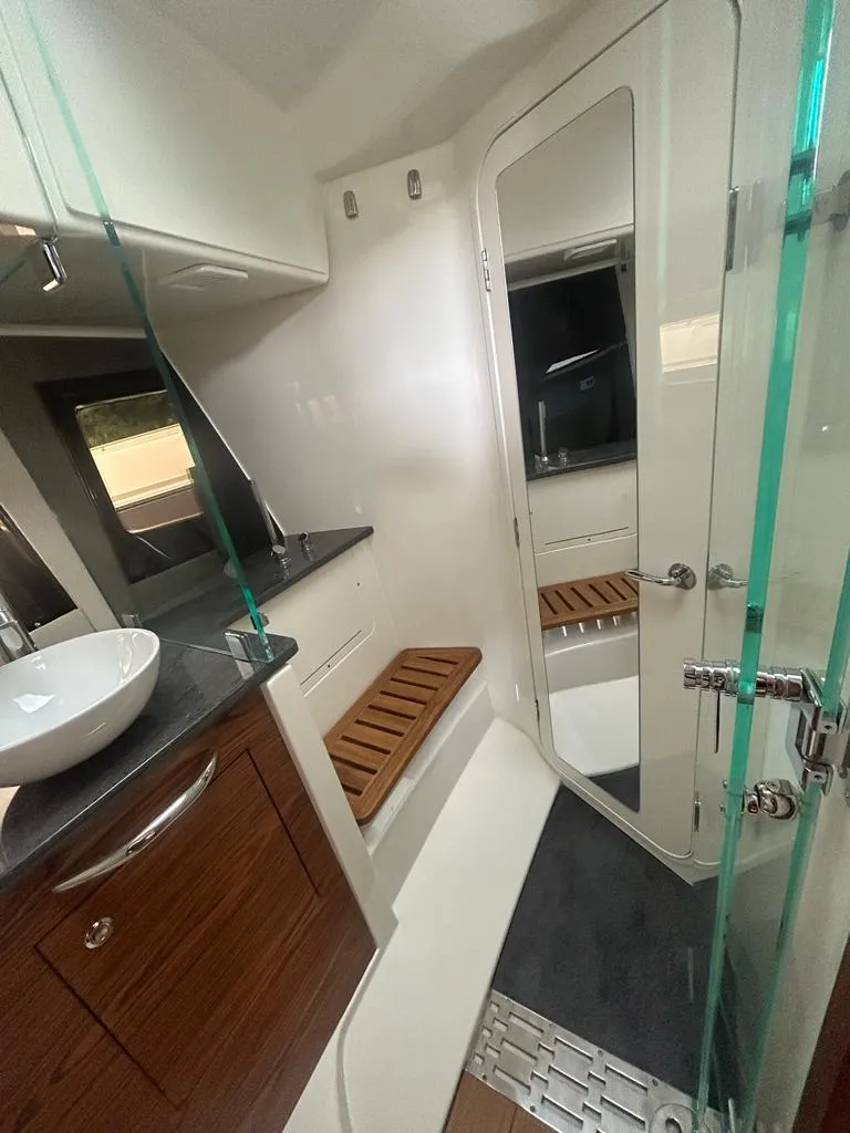 Slide: The Image of 2024 Boston Whaler 405 Conquest bathroom with modern fixtures and wooden accents. - 13