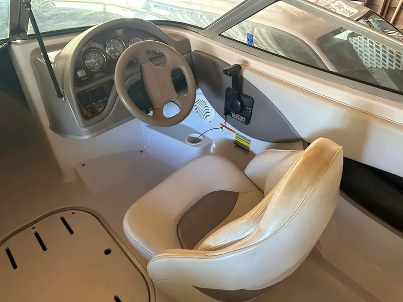 Slide: The Image of 2003 Four Winns 180 Freedom I/O boat cockpit with steering wheel and captain's chair. - 11