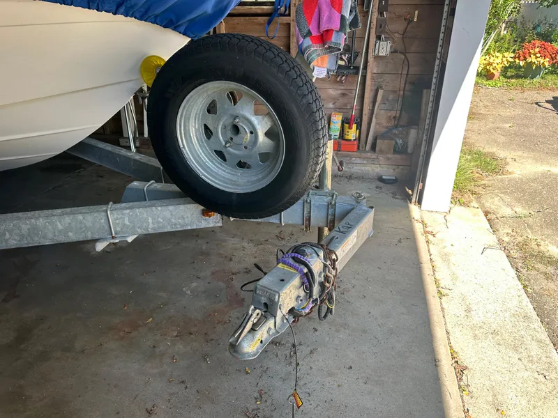 Slide: The Image of 2003 Four Winns 180 Freedom I/O boat trailer hitch and spare tire in a garage. - 3