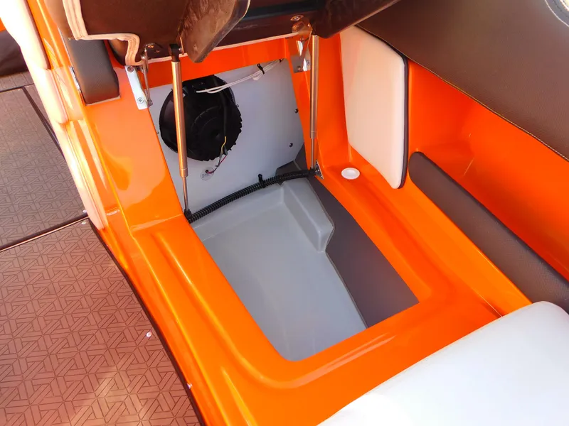 Slide: The Image of 2024 Crownline 240 SS LPX boat storage compartment with orange and white interior. - 10
