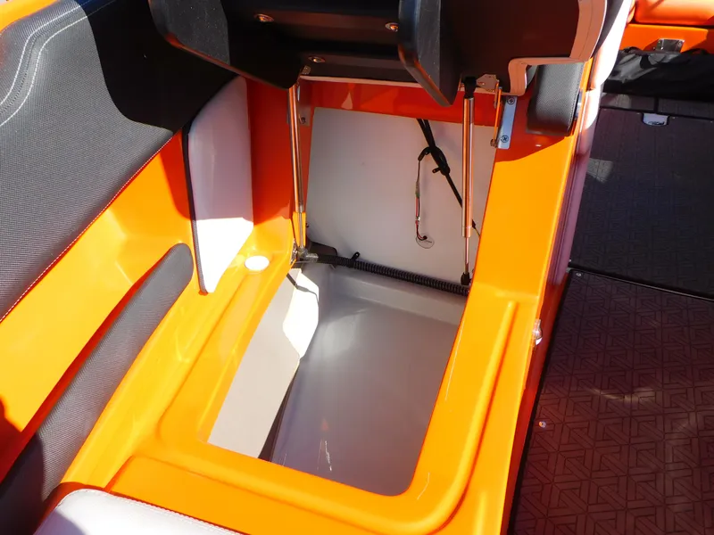 Slide: The Image of 2024 Crownline 240 SS LPX boat storage compartment with orange and black interior. - 11