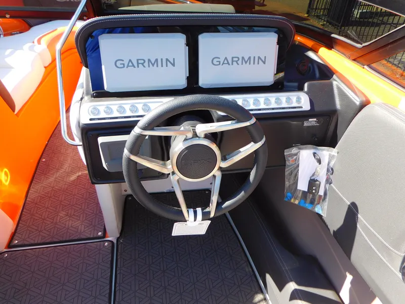 Slide: The Image of 2024 Crownline 240 SS LPX boat dashboard with dual Garmin displays and steering wheel. - 7