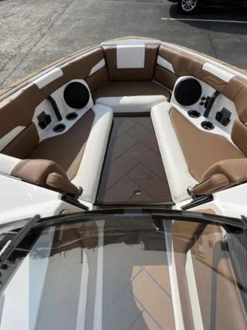 Slide: The Image of 2023 Malibu 26 LSV boat interior with brown and white seating. - 11